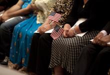 Immigrants holding American flags as they become citizens with the help of ACCESS services.